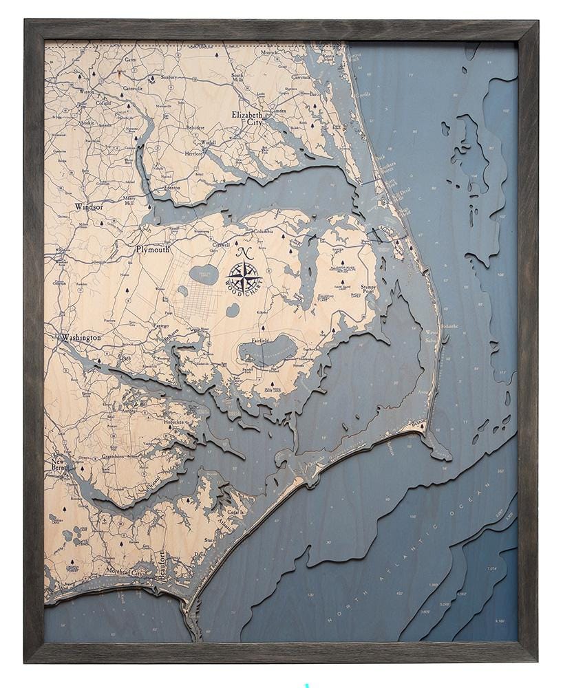 Outer Banks, North Carolina 3D layered wood map in laser-cut Baltic birch, shown framed against a light wall
