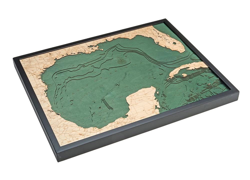 Gulf Of America 3D layered wood map in laser-cut Baltic birch, shown framed against a light wall