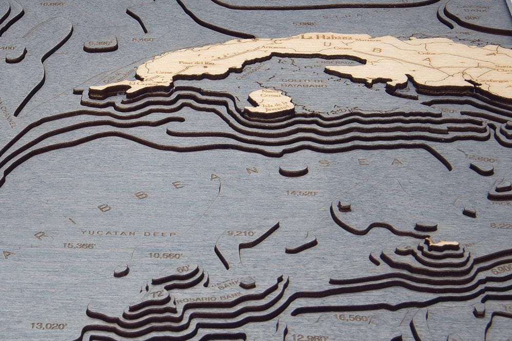 Gulf Of America 3D layered wood map in laser-cut Baltic birch, shown framed against a light wall