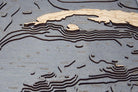 Gulf Of America 3D layered wood map in laser-cut Baltic birch, shown framed against a light wall