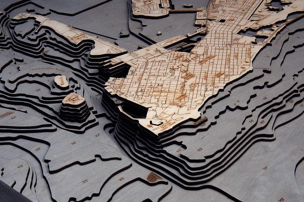 Key West, Florida 3D layered wood map in laser-cut Baltic birch, shown framed against a light wall