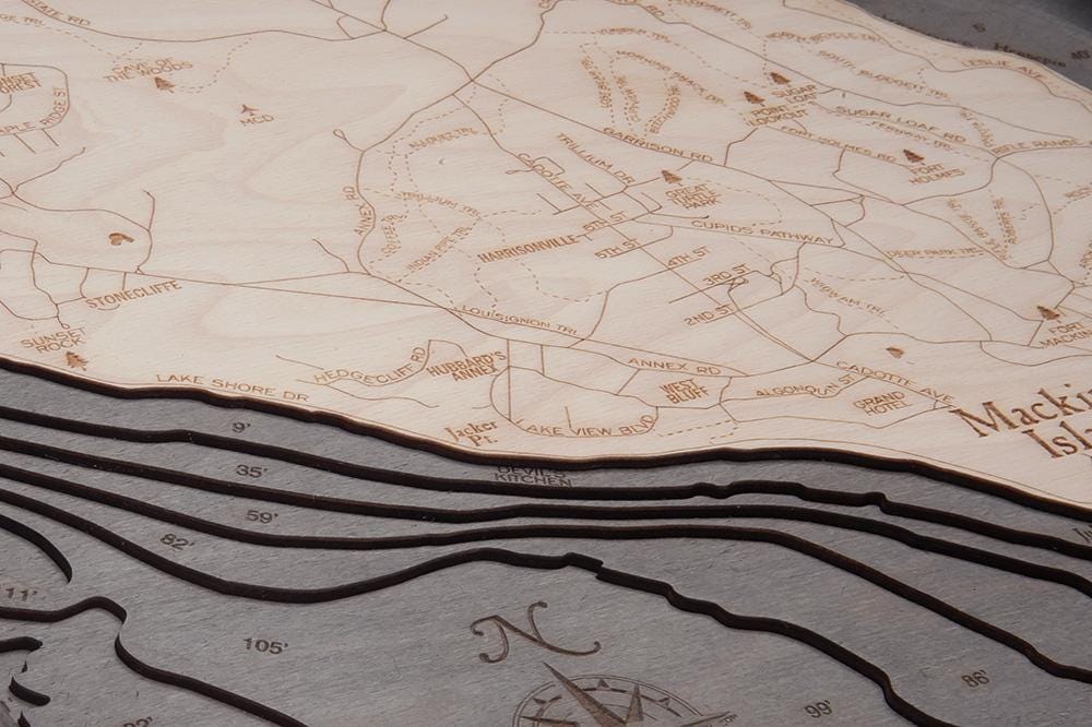 Mackinac Island, Michigan 3D layered wood map in laser-cut Baltic birch, shown framed against a light wall