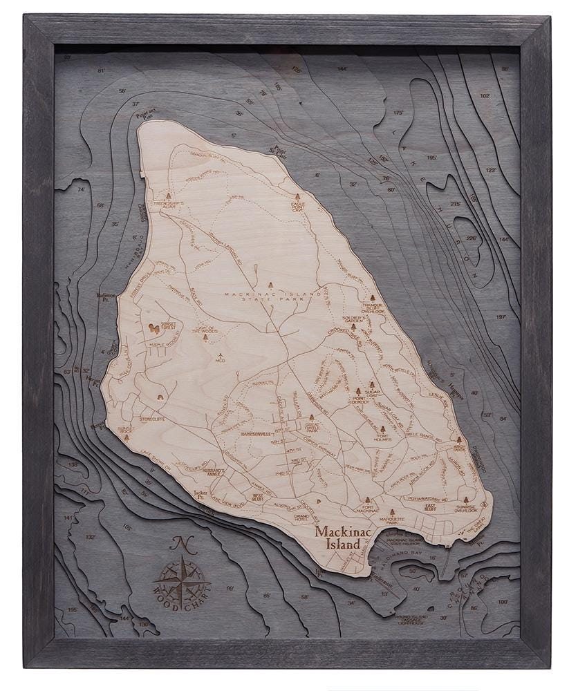 Mackinac Island, Michigan 3D layered wood map in laser-cut Baltic birch, shown framed against a light wall