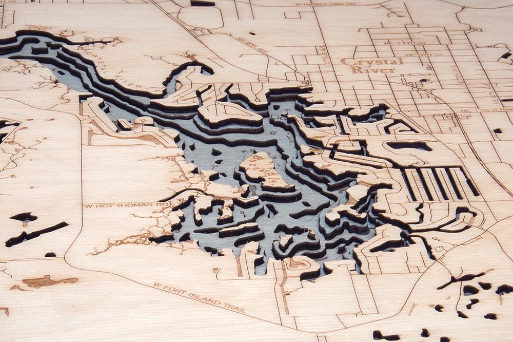 Crystal River, Florida 3D layered wood map in laser-cut Baltic birch, shown framed against a light wall
