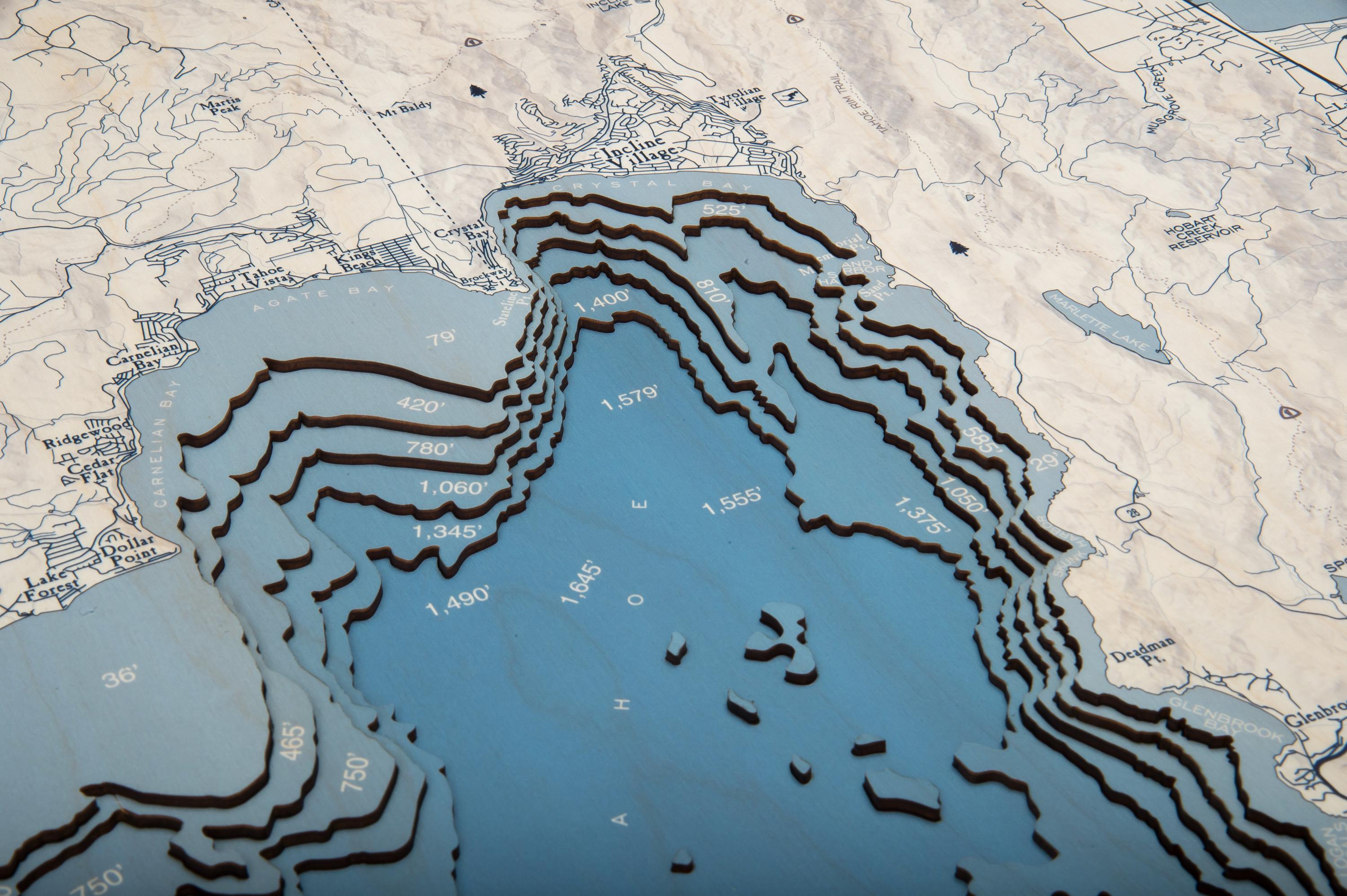 Lake Tahoe, California 3D layered wood map in laser-cut Baltic birch, shown framed against a light wall