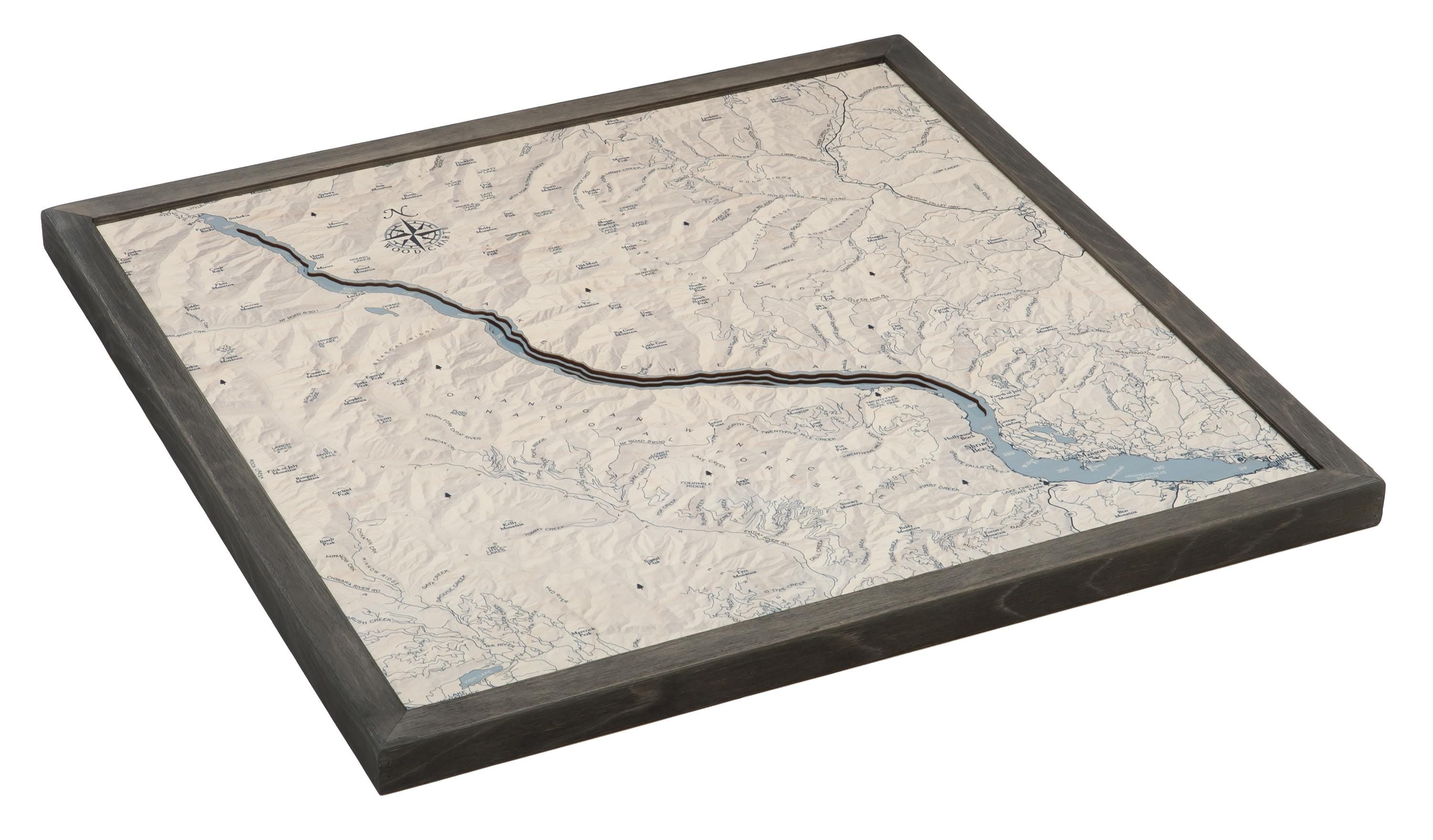Lake Chelan, Washington 3D layered wood map in laser-cut Baltic birch, shown framed against a light wall