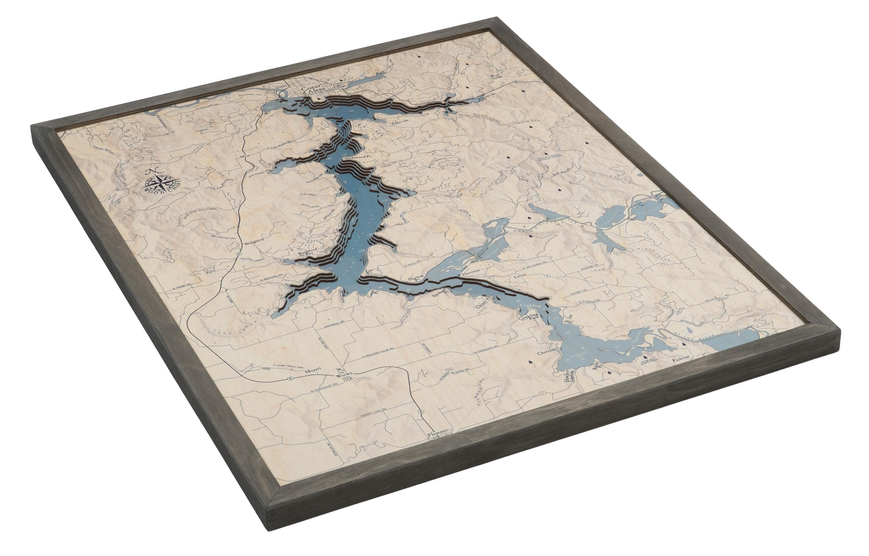 Lake Coeur d'Alene, Idaho 3D layered wood map in laser-cut Baltic birch, shown framed against a light wall