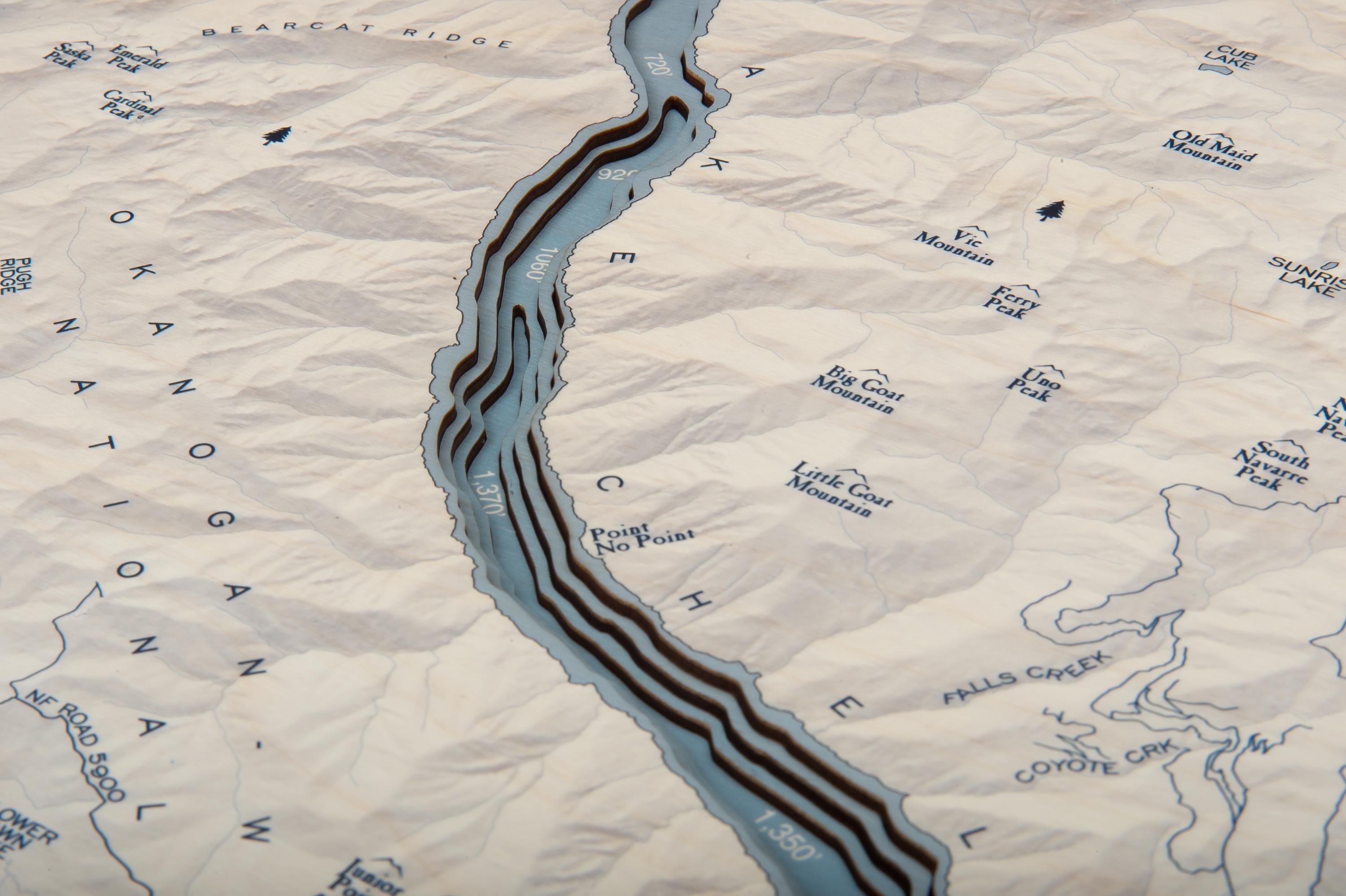 Lake Chelan, Washington 3D layered wood map in laser-cut Baltic birch, shown framed against a light wall