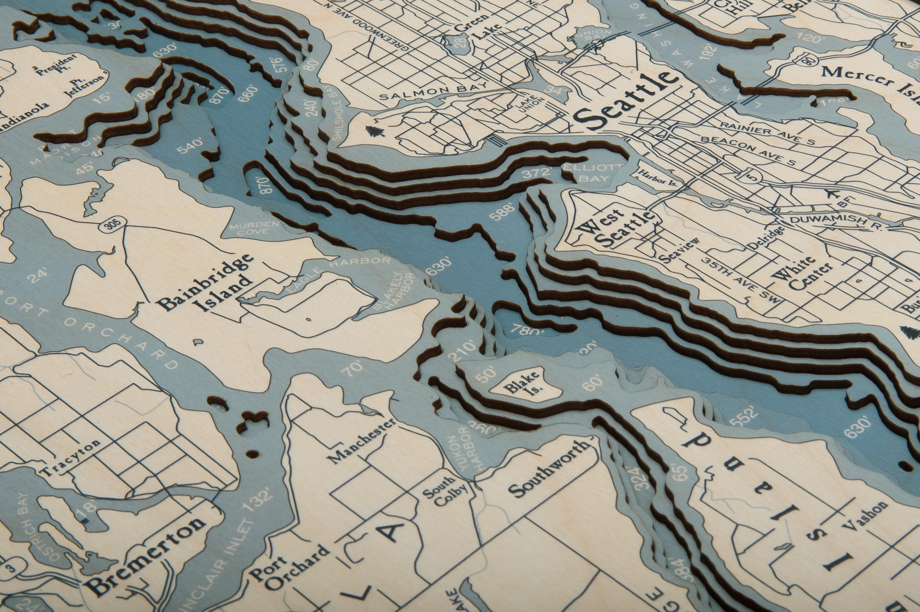Puget Sound, Washington 3D layered wood map in laser-cut Baltic birch, shown framed against a light wall