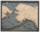 Alaska 3D layered wood map in laser-cut Baltic birch, shown framed against a light wall