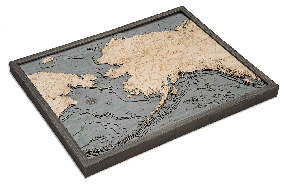 Alaska 3D layered wood map in laser-cut Baltic birch, shown framed against a light wall