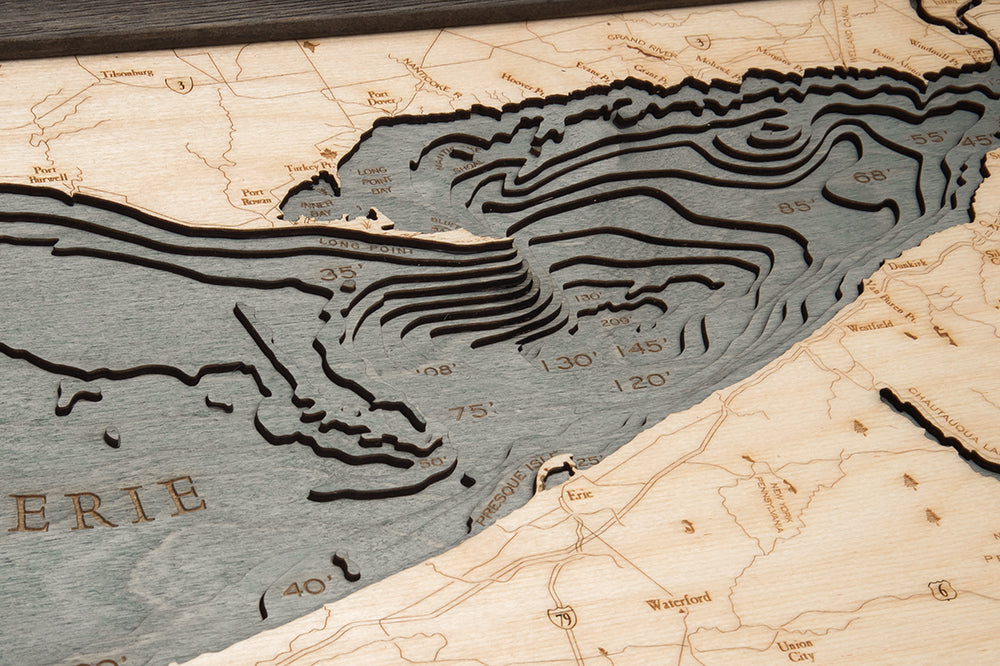 Lake Erie 3D layered wood map in laser-cut Baltic birch, shown framed against a light wall