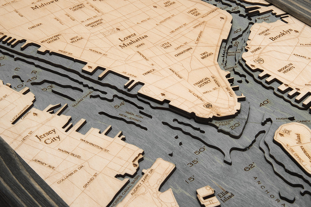 Manhattan, New York 3D layered wood map in laser-cut Baltic birch, shown framed against a light wall