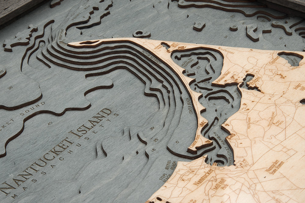 Nantucket, Massachusetts 3D layered wood map in laser-cut Baltic birch, shown framed against a light wall