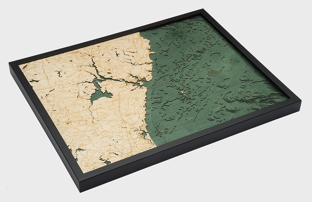 New Hampshire Coast 3D layered wood map in laser-cut Baltic birch, shown framed against a light wall