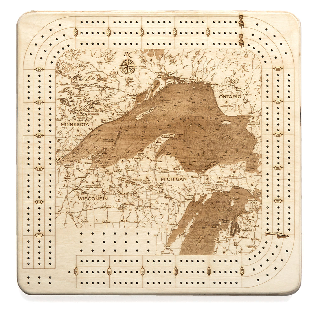 Lake Superior, Michigan wood cribbage board in laser-cut Baltic birch, shown framed against a light wall