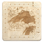 Lake Superior, Michigan wood cribbage board in laser-cut Baltic birch, shown framed against a light wall