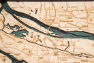 Portland, Oregon 3D layered wood map in laser-cut Baltic birch, shown framed against a light wall
