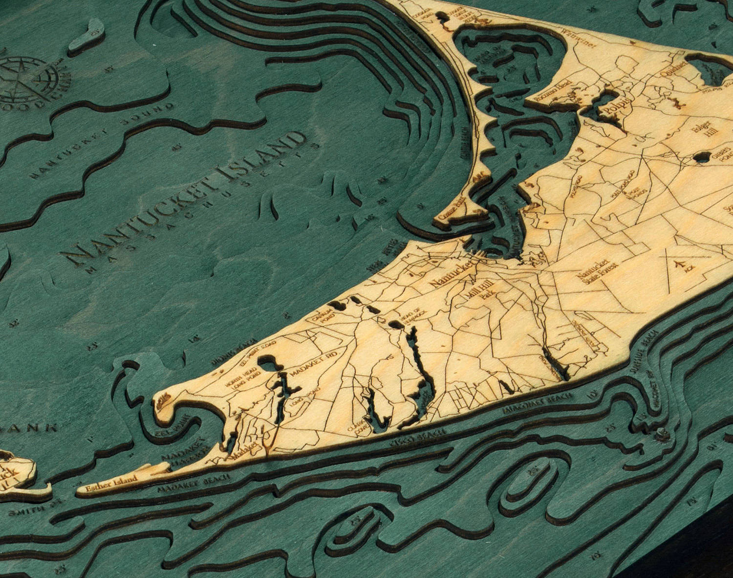 Nantucket, Massachusetts 3D layered wood map in laser-cut Baltic birch, shown framed against a light wall