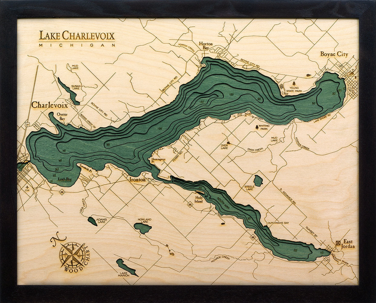 Lake Charlevoix, Michigan 3D layered wood map in laser-cut Baltic birch, shown framed against a light wall