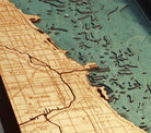 Chicago, Illinois 3D layered wood map in laser-cut Baltic birch, shown framed against a light wall