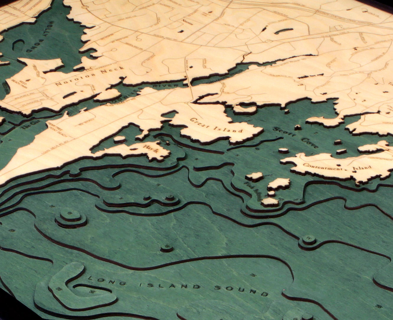 Darien, Connecticut 3D layered wood map in laser-cut Baltic birch, shown framed against a light wall