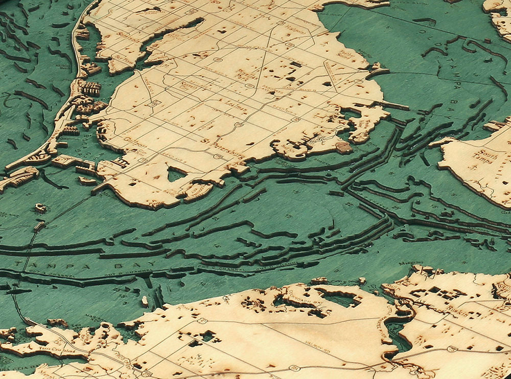 Tampa Bay, Florida 3D layered wood map in laser-cut Baltic birch, shown framed against a light wall