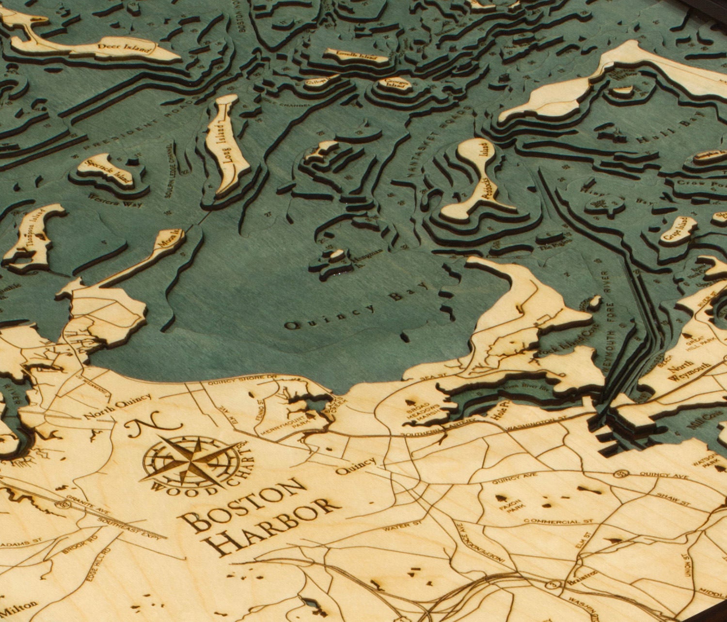 Boston Harbor, Massachusetts 3D layered wood map in laser-cut Baltic birch, shown framed against a light wall
