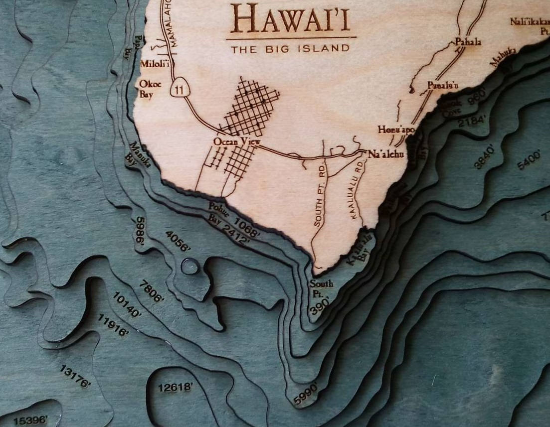 The Big Island, Hawaii 3D layered wood map in laser-cut Baltic birch, shown framed against a light wall