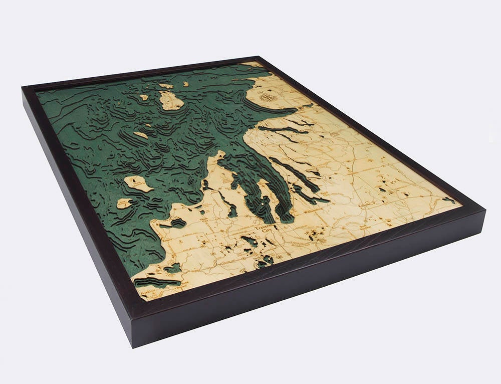 Northwest Michigan 3D layered wood map in laser-cut Baltic birch, shown framed against a light wall
