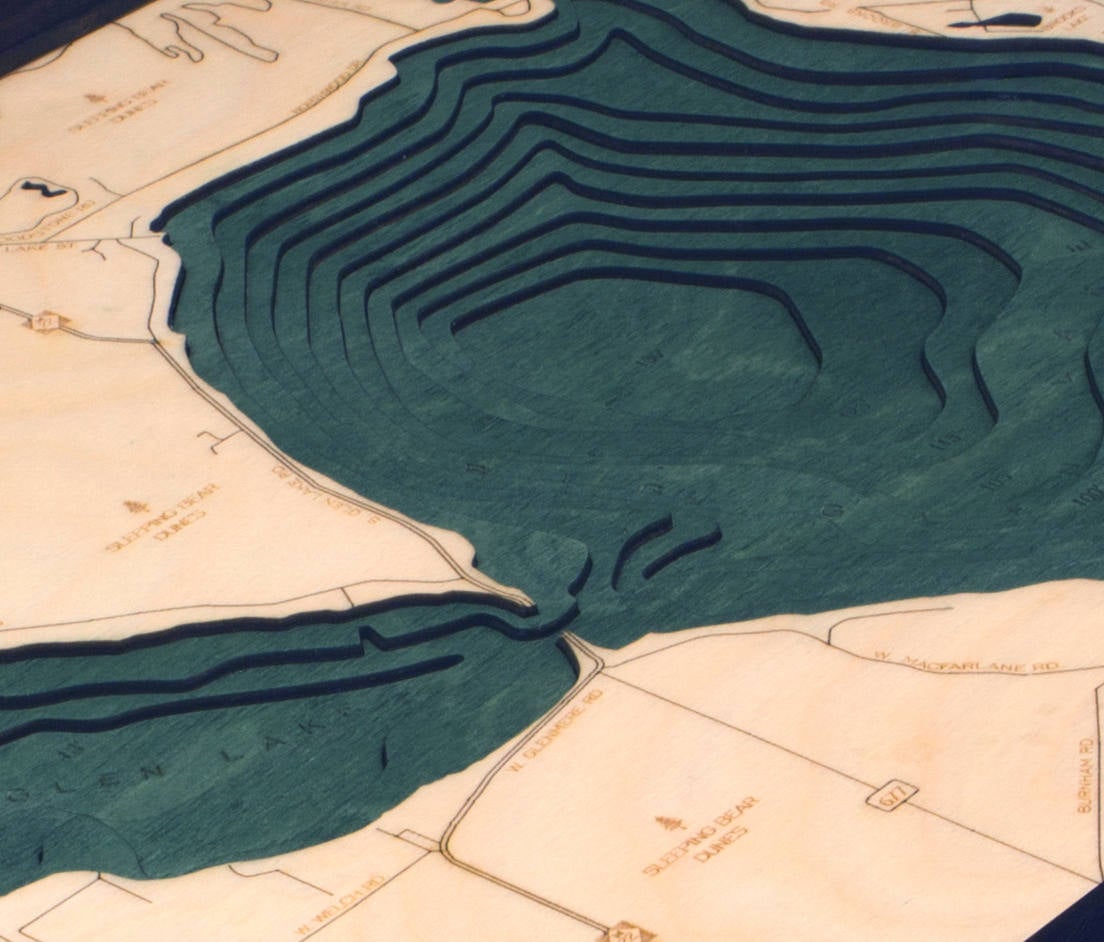 Glen Lake, Michigan 3D layered wood map in laser-cut Baltic birch, shown framed against a light wall