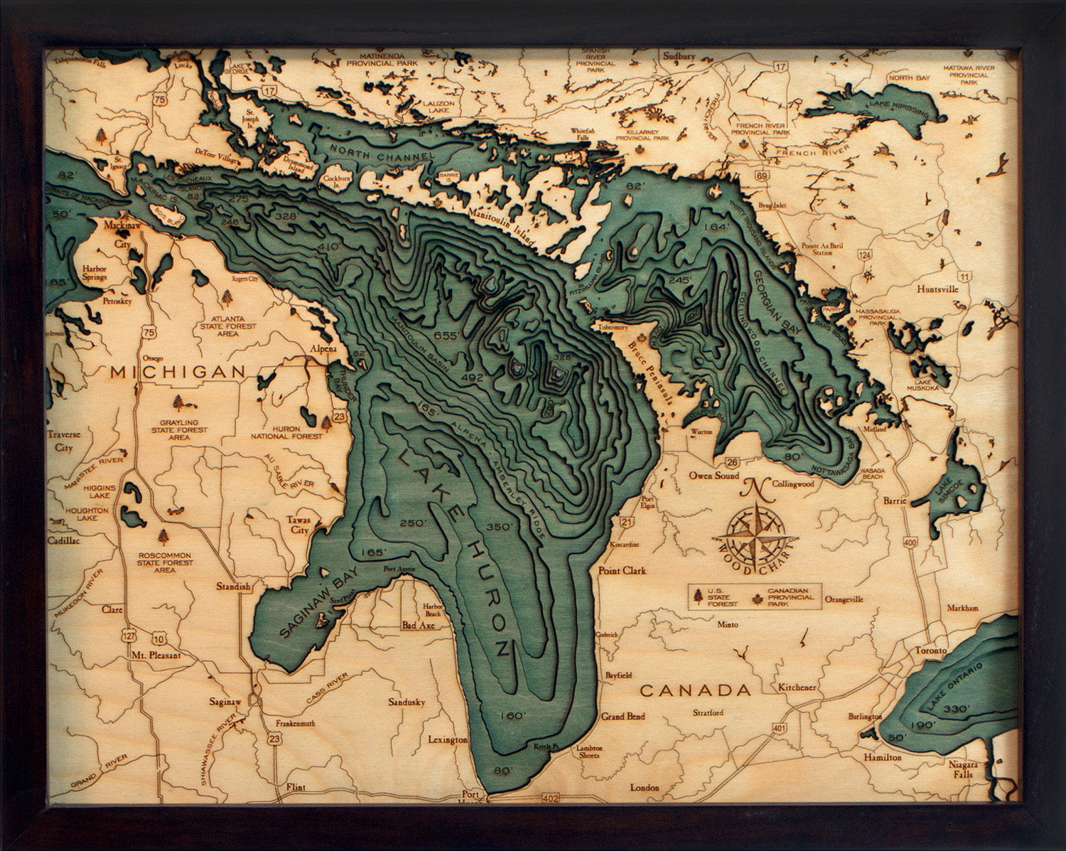 Lake Huron, Michigan 3D layered wood map in laser-cut Baltic birch, shown framed against a light wall