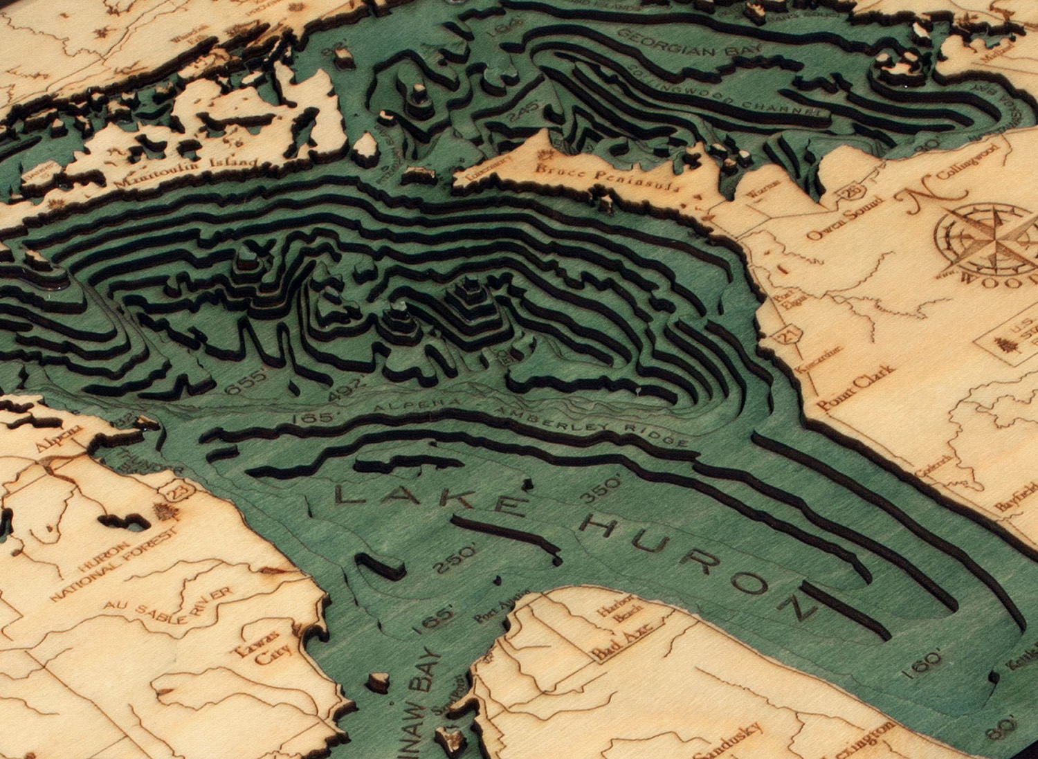 Lake Huron, Michigan 3D layered wood map in laser-cut Baltic birch, shown framed against a light wall