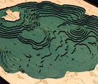 Crater Lake, Oregon 3D layered wood map in laser-cut Baltic birch, shown framed against a light wall