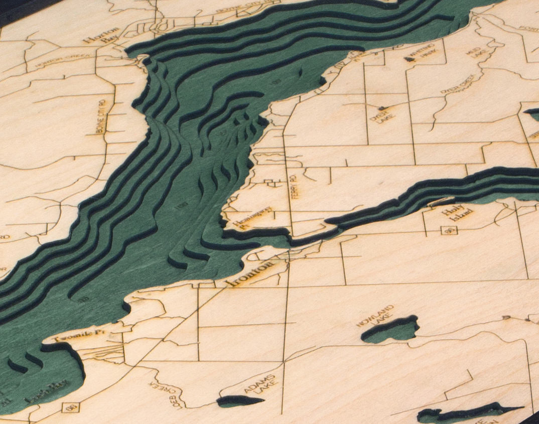 Lake Charlevoix, Michigan 3D layered wood map in laser-cut Baltic birch, shown framed against a light wall