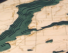 Lake Charlevoix, Michigan 3D layered wood map in laser-cut Baltic birch, shown framed against a light wall