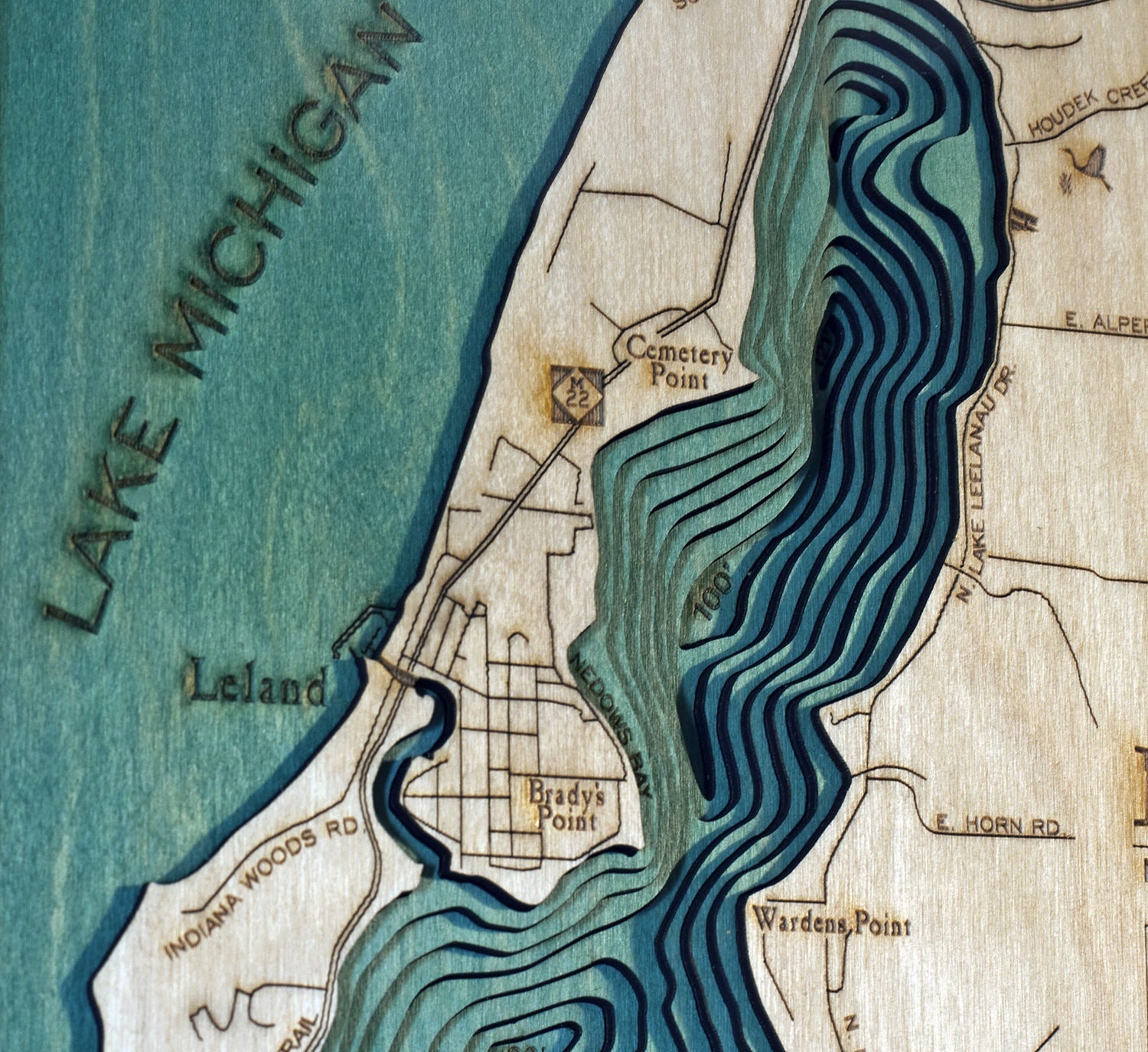 Lake Leelanau, Michigan 3D layered wood map in laser-cut Baltic birch, shown framed against a light wall