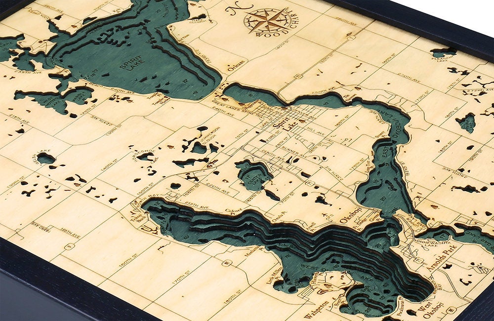 Lake Okoboji, Iowa 3D layered wood map in laser-cut Baltic birch, shown framed against a light wall