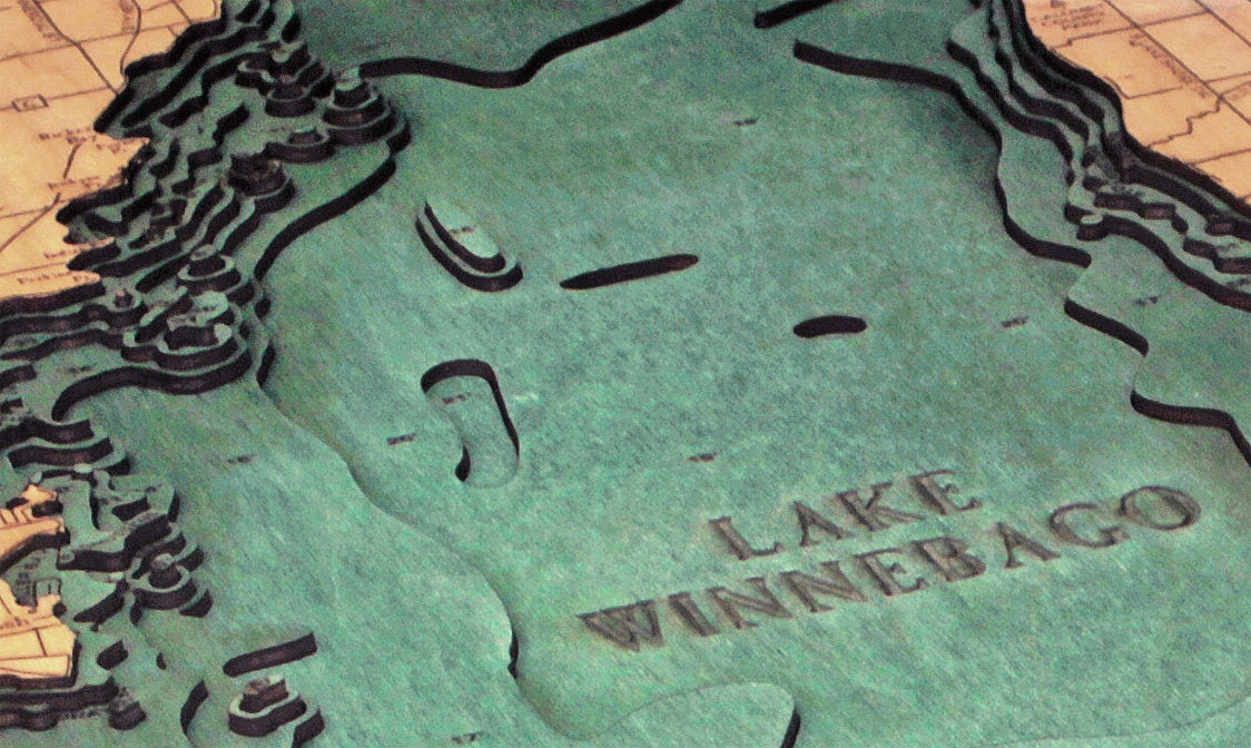 Lake Winnebago, Wisconsin 3D layered wood map in laser-cut Baltic birch, shown framed against a light wall