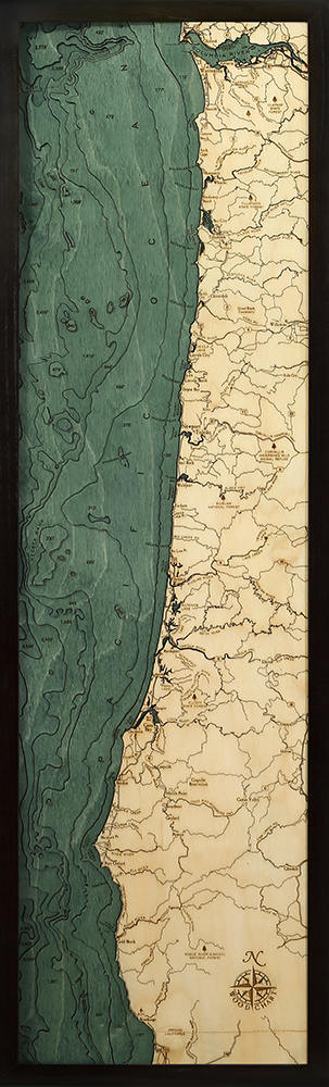 Oregon Coast 3D layered wood map in laser-cut Baltic birch, shown framed against a light wall