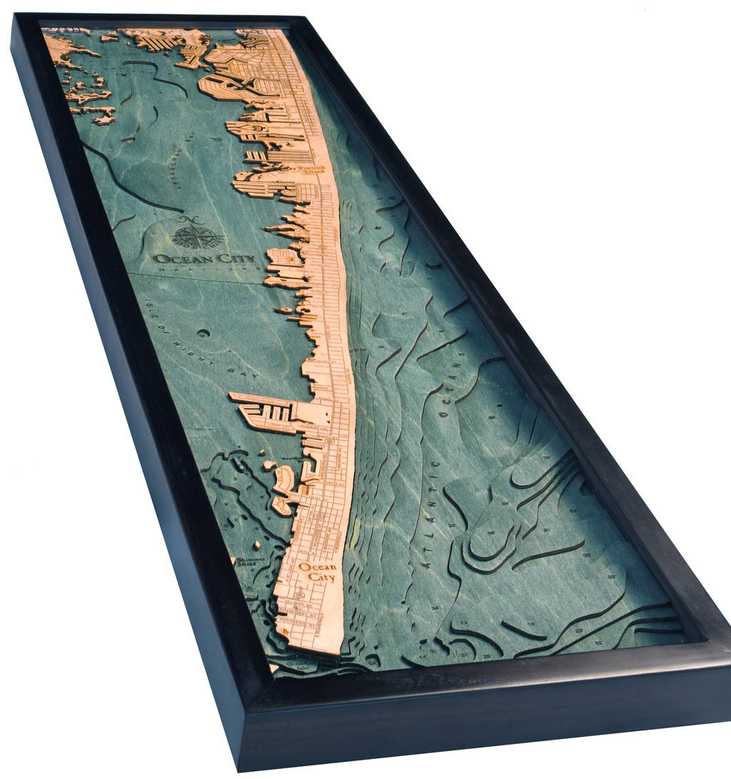 Ocean City, Maryland 3D layered wood map in laser-cut Baltic birch, shown framed against a light wall