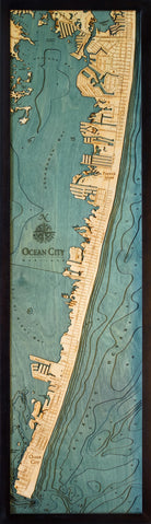 Ocean City, Maryland 3D layered wood map in laser-cut Baltic birch, shown framed against a light wall