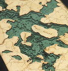Moosehead Lake, Maine 3D layered wood map in laser-cut Baltic birch, shown framed against a light wall