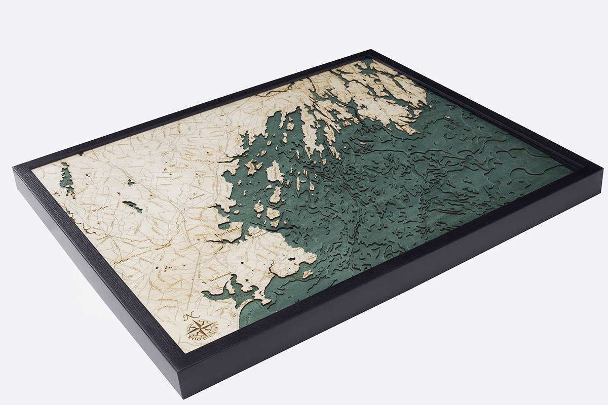 Portland, Maine 3D layered wood map in laser-cut Baltic birch, shown framed against a light wall