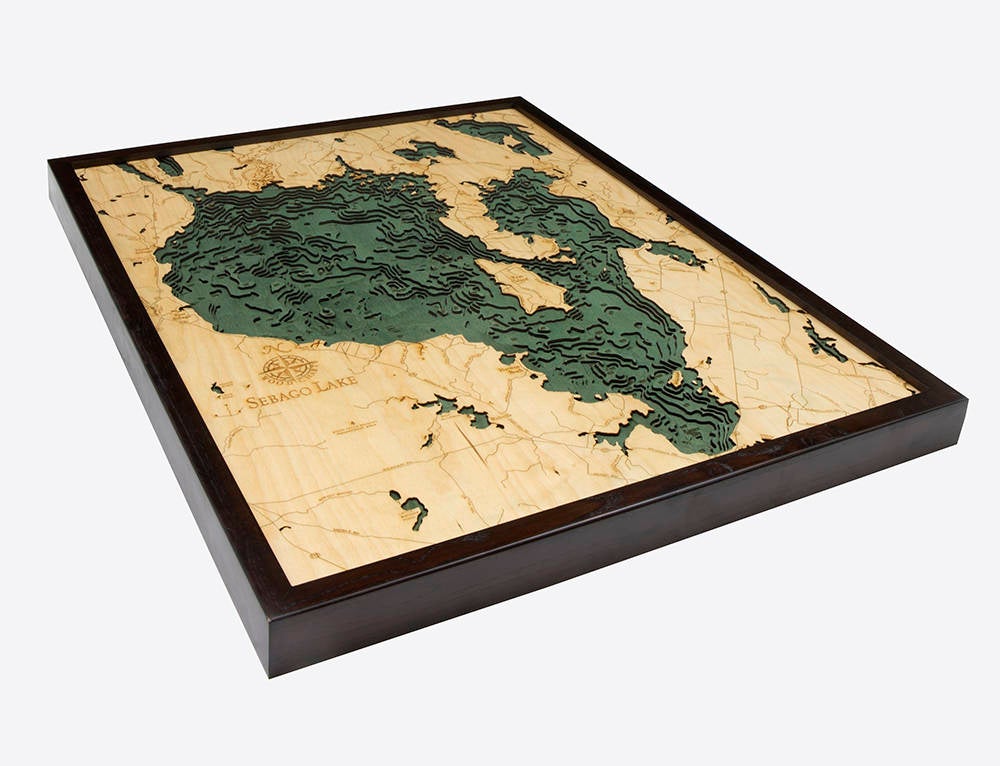 Sebago Lake, Maine 3D layered wood map in laser-cut Baltic birch, shown framed against a light wall