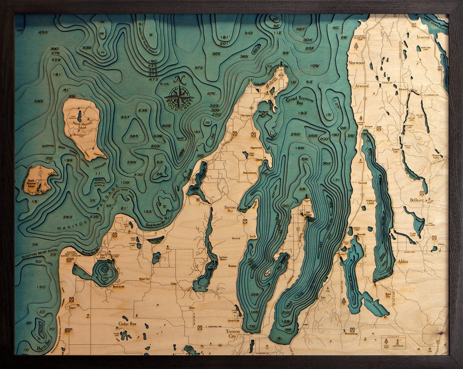 Grand Traverse Bay, Michigan 3D layered wood map in laser-cut Baltic birch, shown framed against a light wall