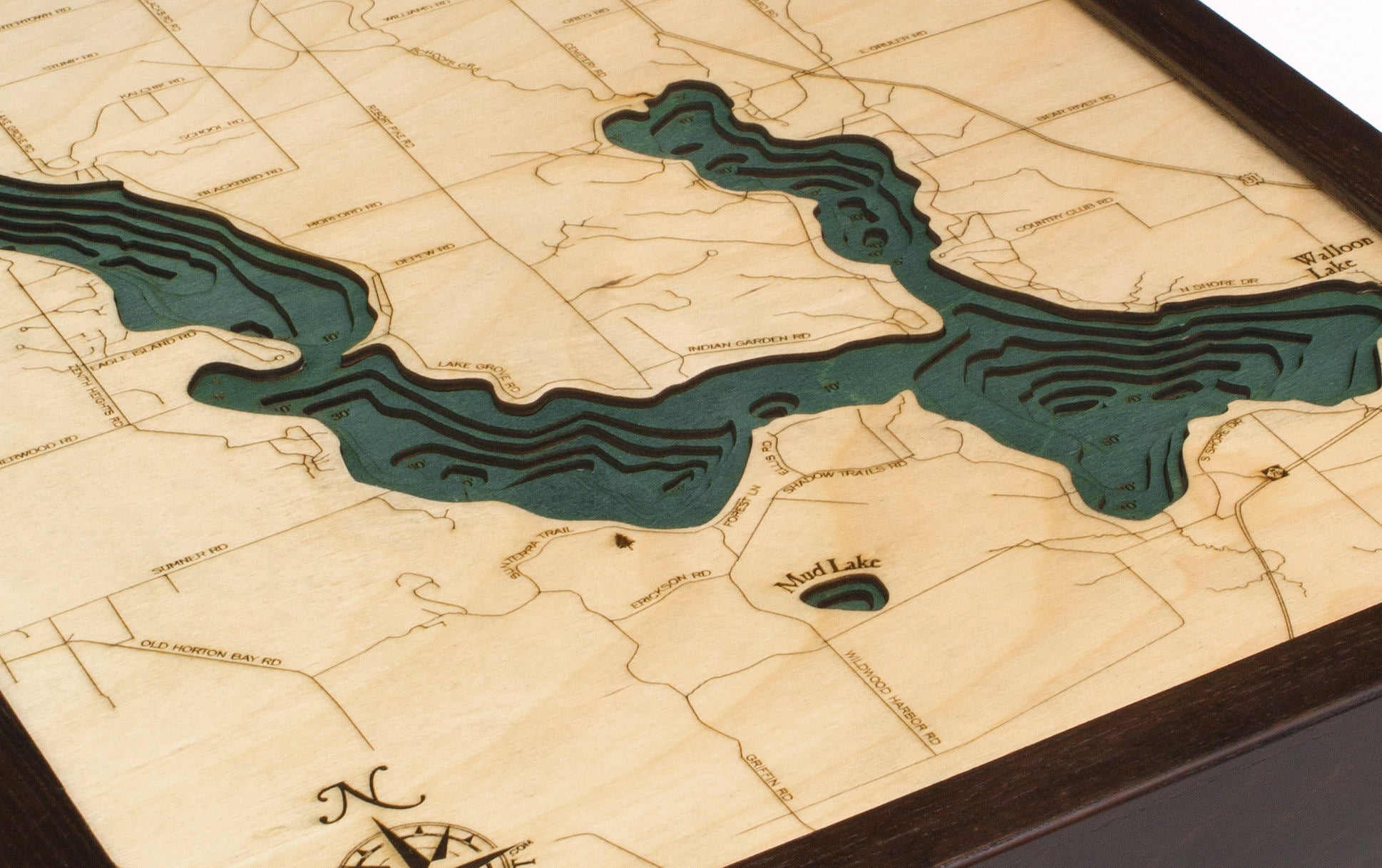 Walloon Lake, Michigan 3D layered wood map in laser-cut Baltic birch, shown framed against a light wall