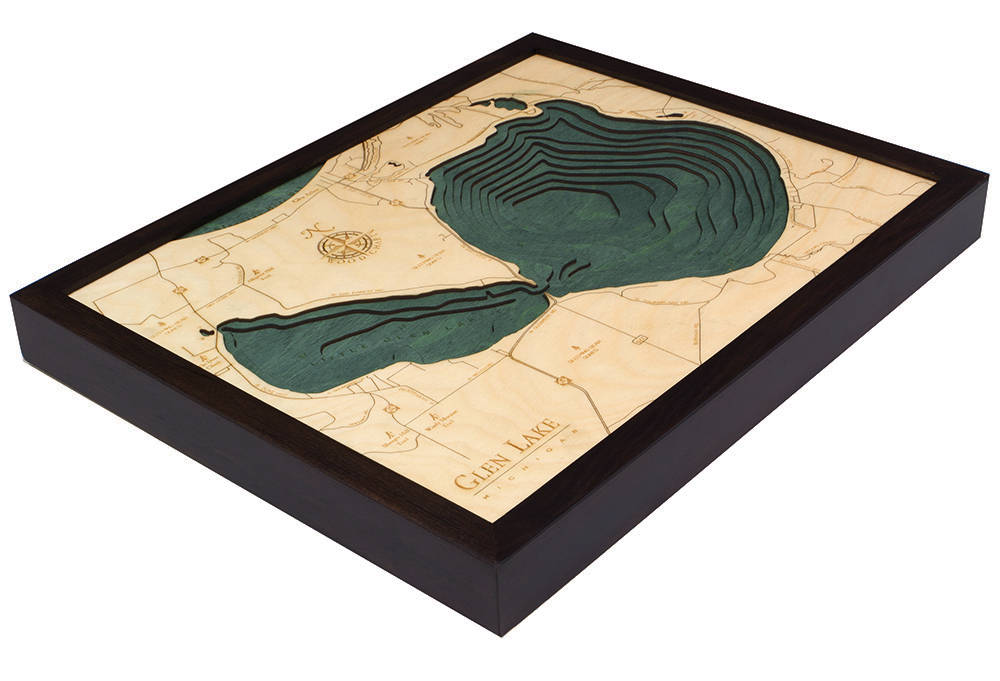 Glen Lake, Michigan 3D layered wood map in laser-cut Baltic birch, shown framed against a light wall