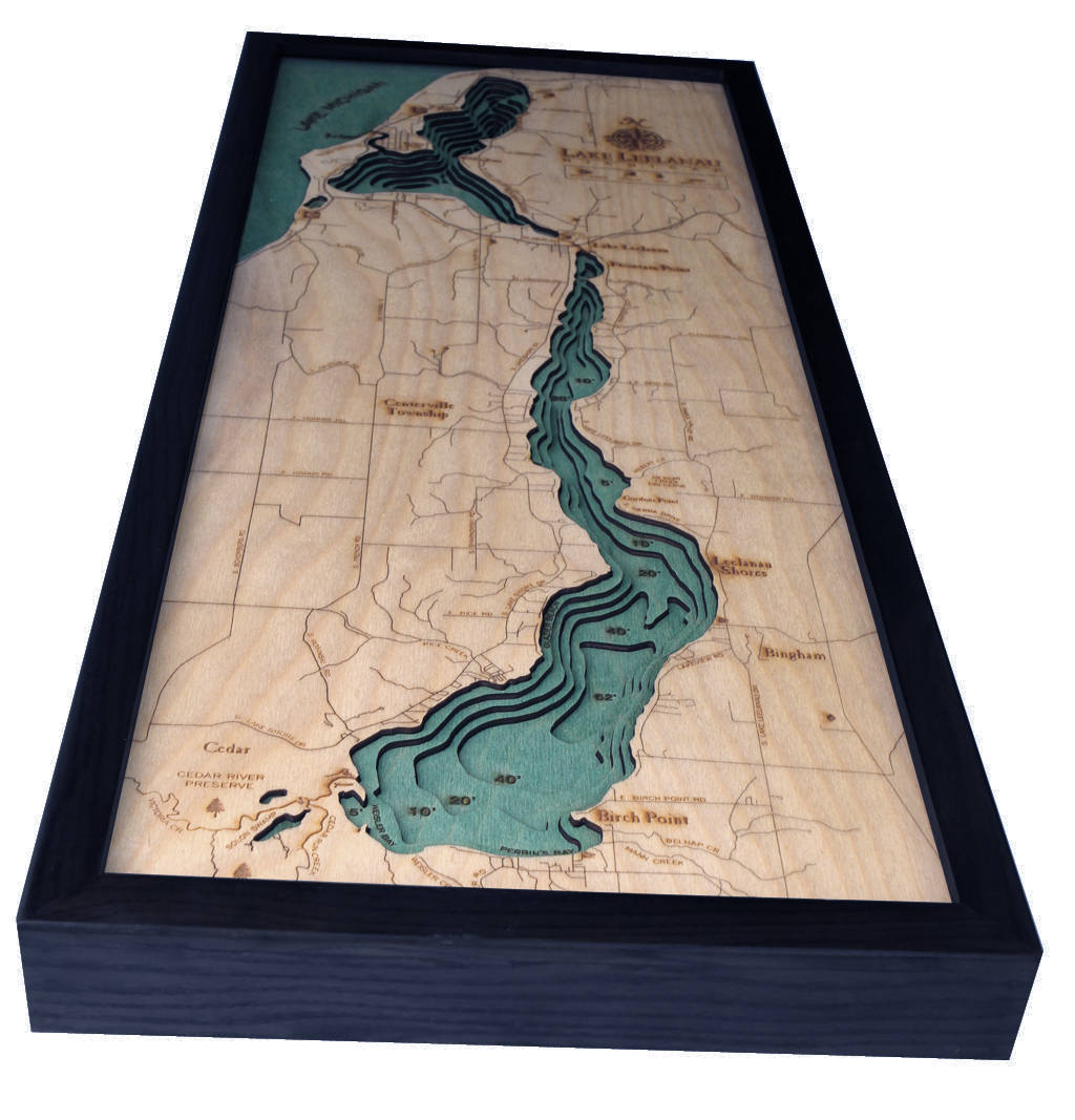 Lake Leelanau, Michigan 3D layered wood map in laser-cut Baltic birch, shown framed against a light wall