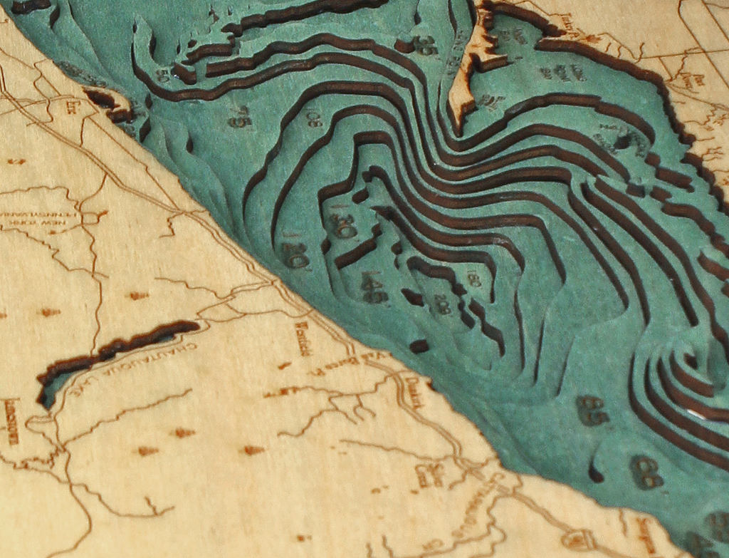 Lake Erie 3D layered wood map in laser-cut Baltic birch, shown framed against a light wall